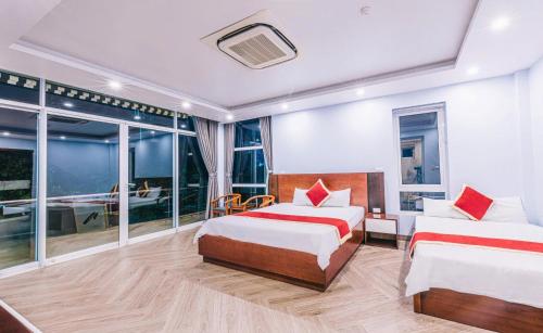 two beds in a room with a balcony at Happy Villa in Sầm Sơn