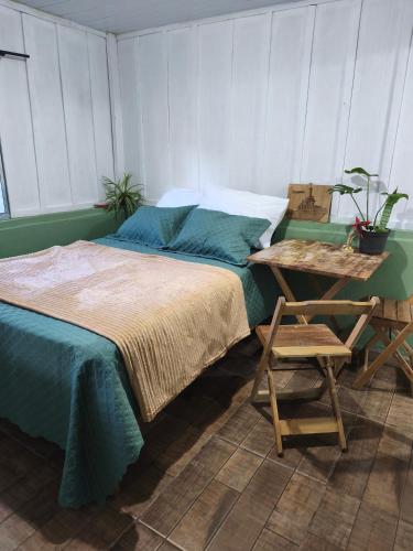a bedroom with a bed and a table and a chair at Canto da restinga in Paranaguá