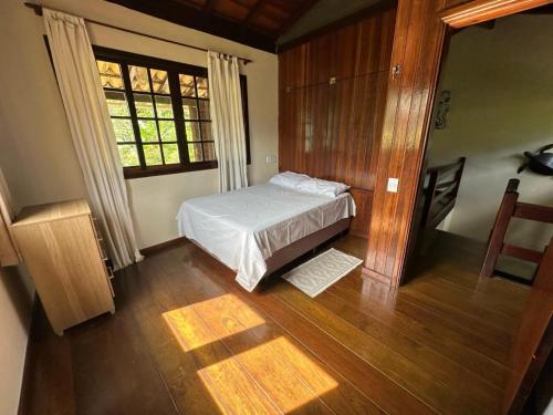 a small bedroom with a bed and a window at Trindade Casa Amarela in Trindade
