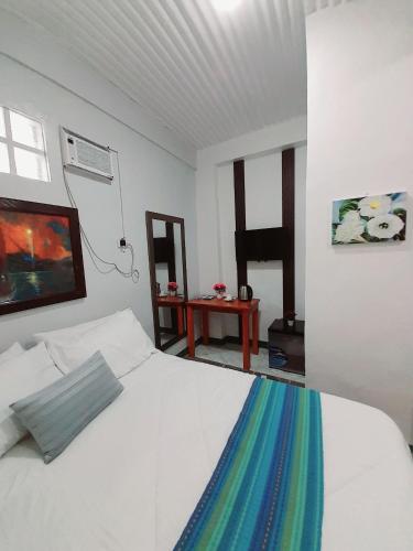 ein Schlafzimmer mit einem weißen Bett mit einer bunten Decke in der Unterkunft Solmana Suites in Sampong