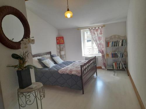 a bedroom with a bed and a mirror at Maison en pierres rénovée avec patio à Ferrières-sur-Sichon - FR-1-489-191 in Ferrières-sur-Sichon