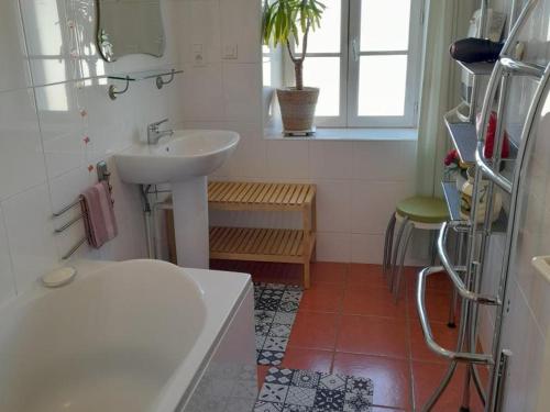 a white bathroom with a sink and a window at Maison en pierres rénovée avec patio à Ferrières-sur-Sichon - FR-1-489-191 in Ferrières-sur-Sichon