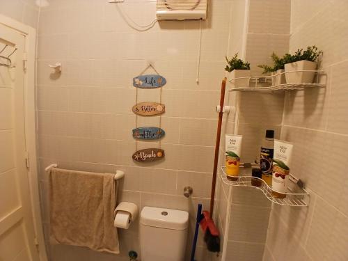a small bathroom with a toilet and shelves on the wall at Aqua Palms Resort D101 in El Gouna