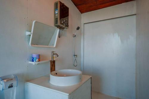 a bathroom with a sink and a mirror on the wall at Mon Ngo misty haven B1 in Ban Mae Ta Man