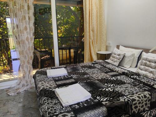 a bedroom with a bed with black and white sheets at Eva Beach Side Room in Mandrem