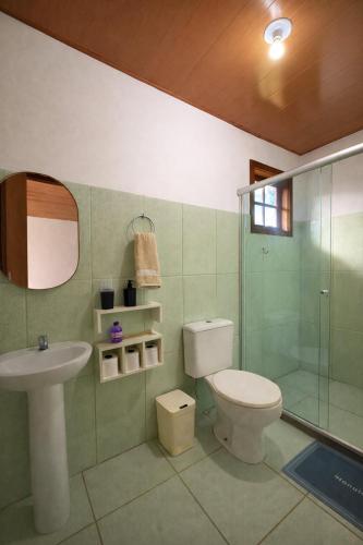 a bathroom with a toilet and a sink and a shower at Chalés do Lago Lumiar in Nova Friburgo