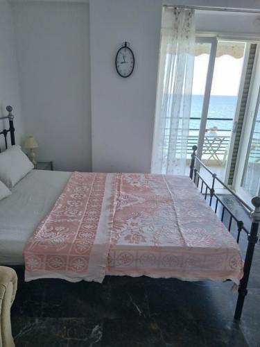 a bedroom with a bed with a clock on the wall at Calma2 in Agioi Theodoroi