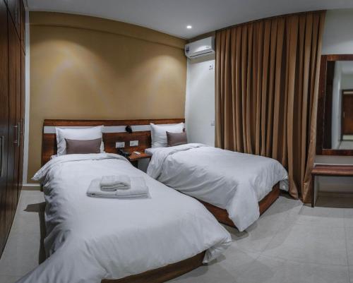 ein Hotelzimmer mit zwei Betten und einem Fenster in der Unterkunft Hotel Rherssllah in Zaïo
