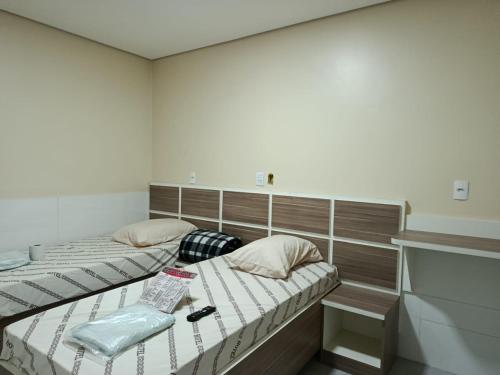 two twin beds in a room with at Hotel cowboy Interlagos próximo do autódromo e transamérica Expo Center in São Paulo