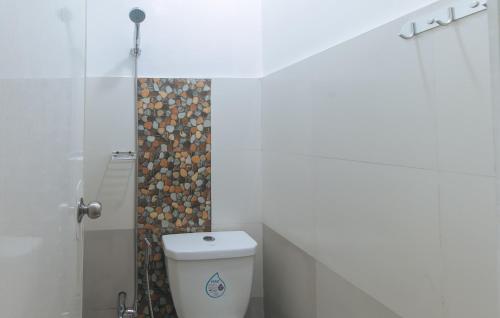 a white bathroom with a toilet and a shower at G Fam Transient by RedDoorz in Manila