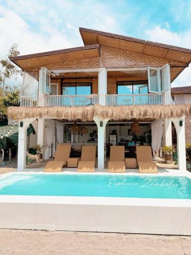 a villa with a swimming pool and a house at Euphoria Zambales in Botolan