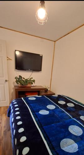 a bedroom with a blue comforter on a bed at Cabaña Evaristo Ivan in Frutillar