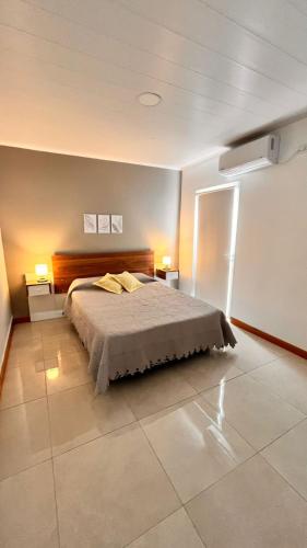 a bedroom with a bed and two lights on the wall at Gris Urbano in Federación