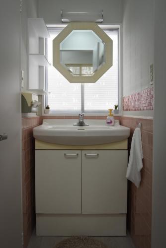 a bathroom with a sink and a mirror at Sai's House Hakuba in Hakuba