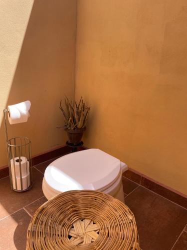 a bathroom with a white toilet and a basket at Eco Glamping Biosfera - Bahia Turquesa in La Ventana