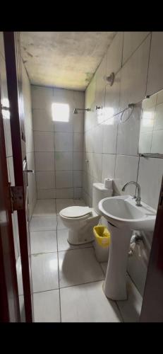 a bathroom with a toilet and a sink at Sítio Resenha in Caucaia