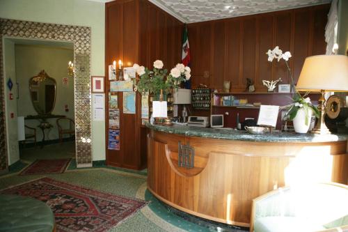 a lobby with a large wooden bar in a building at Hotel Diana in Grado