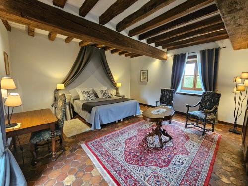 a bedroom with a bed and a table and chairs at Château de Ribourdin in Chevannes