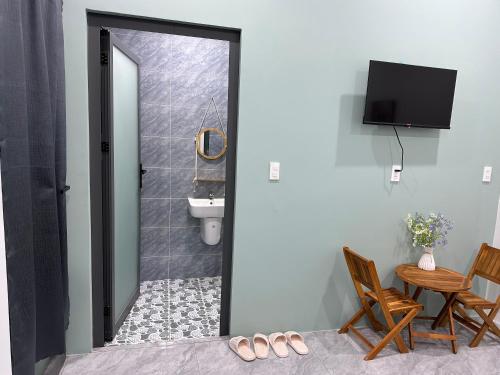 a bathroom with a toilet and a table with chairs at Hera motel in Xã Như Lâm