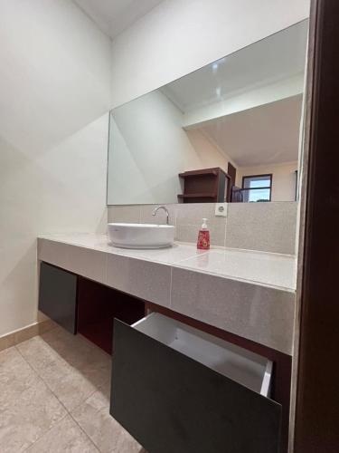 a bathroom counter with a sink and a mirror at Pantai Ayu Homestay in Padangbai