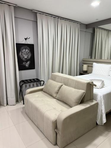a living room with a couch and two beds at Studio Premium - Bairro Nova Yorque Araçatuba in Araçatuba