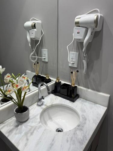a bathroom sink with two cameras on the wall at Studio Premium - Bairro Nova Yorque Araçatuba in Araçatuba