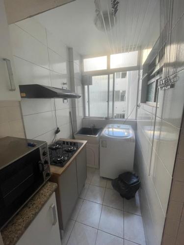 a small kitchen with a stove and a sink at Campinas in São José