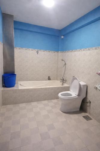 a bathroom with a toilet and a bath tub at Second Home Hotel in Kathmandu