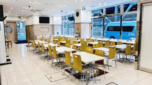 a dining room with tables and yellow chairs at Toyoko Inn Niigata Furumachi in Niigata