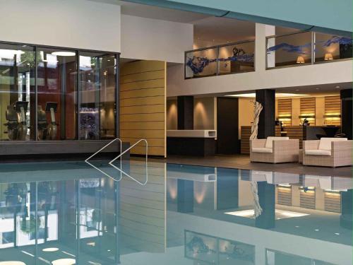 a house with a swimming pool and a living room at PULLMAN Berlin Schweizerhof - City Center, Zoo und Kurfürstendamm in Berlin
