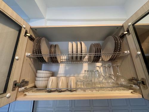 a cupboard with plates and bowls and utensils at Fibonacci Beachfront Apartment in Flic-en-Flac