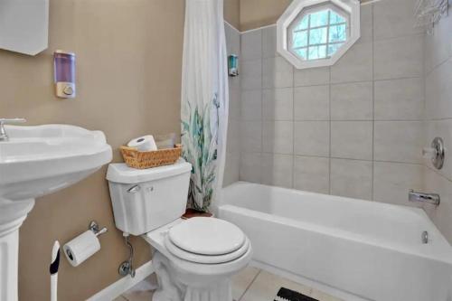 a bathroom with a toilet and a sink and a bath tub at Arrowhead Lakefront Chalet Private Lake Access in Pocono Lake