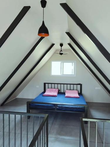 a bedroom with a blue bed in a attic at wild grove resorts in Varagampadi
