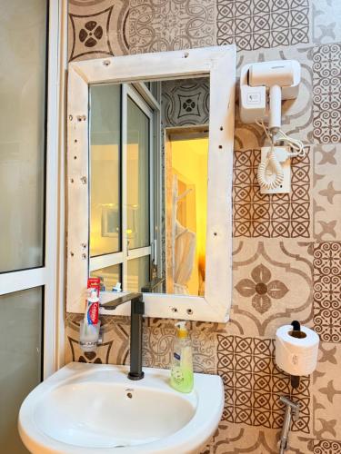 a bathroom with a sink and a mirror at Studio Crème by The Prime Escape in Arusha
