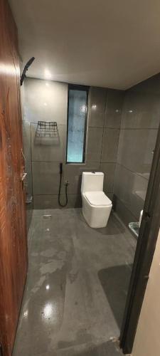 a small bathroom with a toilet and a window at wild grove resorts in Varagampadi