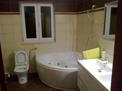 a bathroom with a tub and a toilet and a sink at Apartment in Okrug Gornji 6167 in Trogir