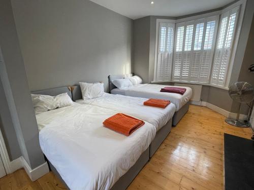 two beds in a room with two windows at Home in Greenwich near the O2 in London