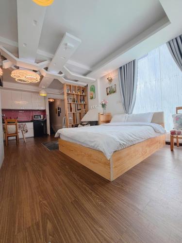 a bedroom with a large bed and a living room at Căn Hộ Vỹ Dạ Đà Lạt in Da Lat