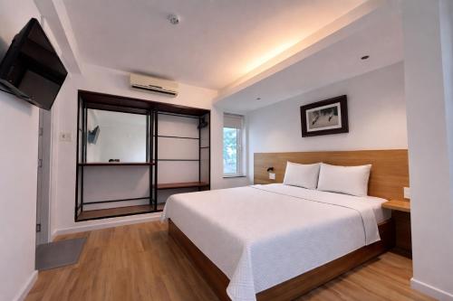 a bedroom with a white bed and a window at The Charm Boutique Hotel Hue in Hue