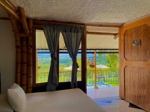 a bedroom with a bed and a window with a view at Hotel La Casona Quindío Eje Cafetero in Montenegro
