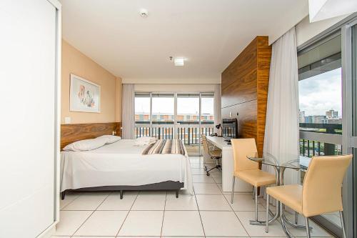 a hotel room with a bed and a table and chairs at Vision Hotel em Brasília 60300 in Brasília