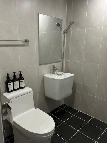 a bathroom with a white toilet and a mirror at momohouse 체스룸 in Chinyŏng-yŏk