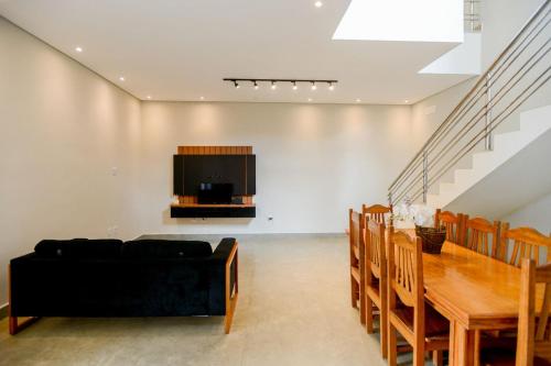 a living room with a couch and a table and chairs at Casa com Piscina Aquecida Churrasqueira e Hidro in Franca