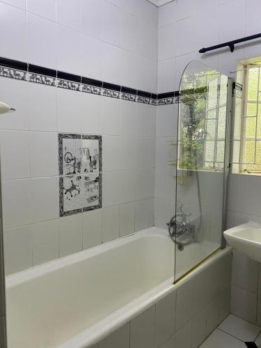 a white bathroom with a tub and a sink at Foundry farmhouse in Bothaʼs Hill