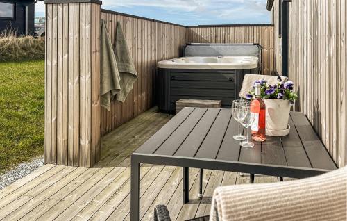a wooden deck with a table and wine glasses at Lovely Home In Haderslev With Sauna in Haderslev