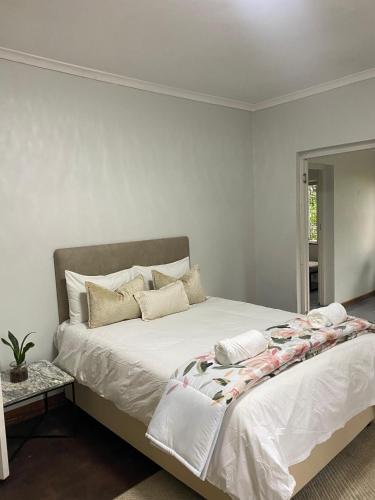 a bedroom with a large bed with white sheets at Foundry farmhouse in Bothaʼs Hill