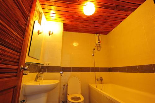 a bathroom with a sink and a toilet and a tub at Sathorn Garden View in Bangkok