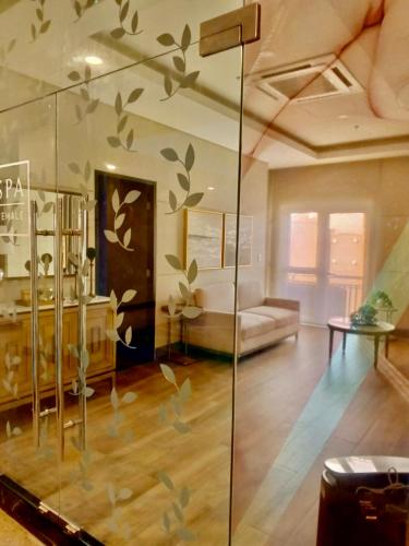 a living room with a glass wall with leaves painted on it at Saint Honore Executive 1 Full bed, 1 Sofa bed 1 Pull out bed 2BR in Iloilo City