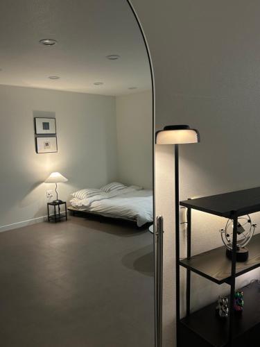 a room with a bed and a lamp and a mirror at momohouse 체스룸 in Chinyŏng-yŏk