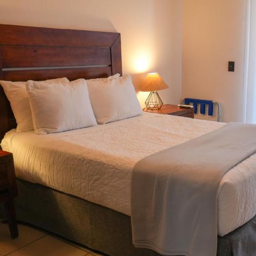 a bedroom with a large bed with white pillows at SUITES LOMBOY & PLAZA in San José del Cabo